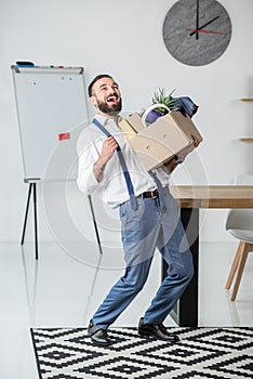 Businessman with cardboard box in hands quitting job