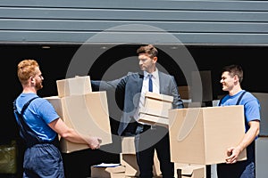 Businessman cardboard boxes near loaders and