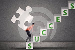 Businessman carry puzzle piece on success stairs