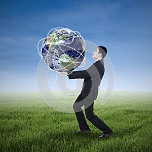 Businessman carrying a globe