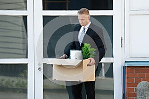 Businessman Carrying His Belongings In Box After Being Fired