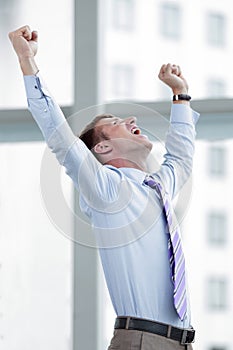 Businessman celebrating with his fists raised in the air