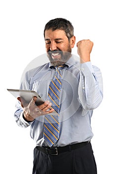 Businessman Celebrating While Looking at Electronic Tablet