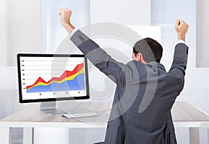 Businessman Celebrating Success At Computer Desk