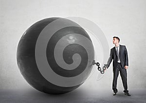 Businessman chained to a large ball