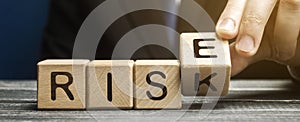 Businessman changes wooden blocks with the words Risk and Rise. Business risk management and growth performance. Risks assessment