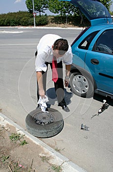 Businessman changing a tire