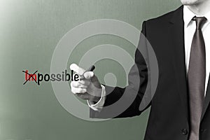 Businessman changing the word impossible into possible