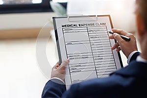 Businessman checking document and completing a insurance claim form at office work, insurance protection concept