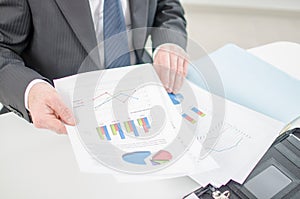 Businessman checking a file with financial graphs