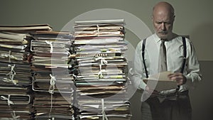 Businessman checking files and piles of paperwork