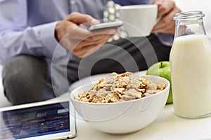 Businessman checking his smartphone during the breakfast time