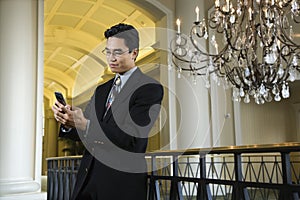 Businessman Checking Messages on Cellphone