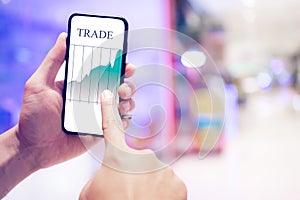 Businessman checking stock market data. He using a mobile phone.Trading on stock market with smartphone