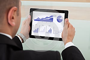 Businessman checking the stock market on digital tablet