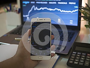 Businessman checking stock market on mobile