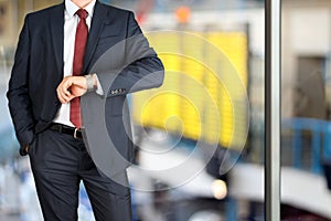 Businessman checking time on his watch at the airport