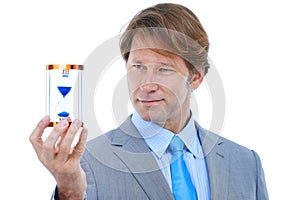 Businessman, checking and time management with hour glass for schedule or limit on a white studio background. Young man