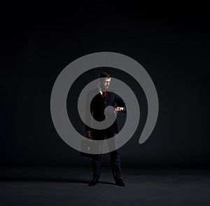 Businessman checking time over black background with copyspace.