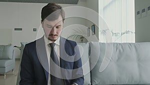 Businessman checks his passport before boarding on the plane in vip lounge hall