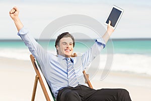 Businessman cheering on the beach