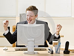 Businessman cheering at Desk