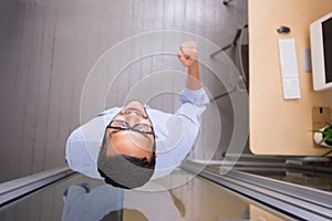 Businessman cheering in office