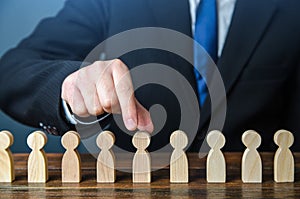 A businessman chooses a person from a row. Recruiting. Headhunter HR. Study and selection of candidates.  photo