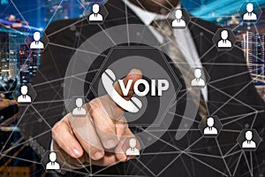 The businessman chooses VOIP button on the touch screen with a futuristic background .The concept VOIP.