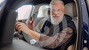 Businessman choosing car and showing keys while sitting inside at modern showroom spbi.