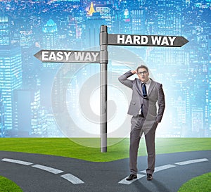 Businessman choosing between hard and easy way