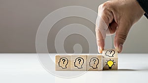 Businessman choosing light bulb icon, full of ideas and creativity on the wooden cube