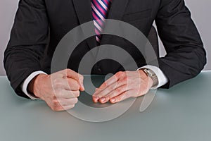 Businessman with clenched fist on desk at office.