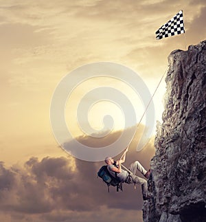 Businessman climb a mountain to get the flag. Achievement business goal and difficult career concept