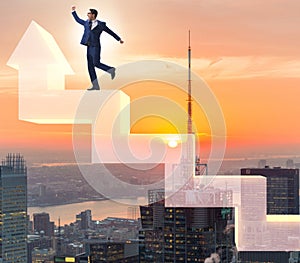 Businessman climbing bar charts in growth concept