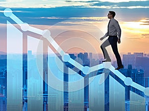 Businessman climbing bar charts in growth concept