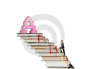 Businessman climbing books stairs toward alphabet A shape blocks