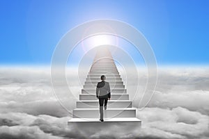 Businessman climbing the concrete stairs with blue sky sunlight