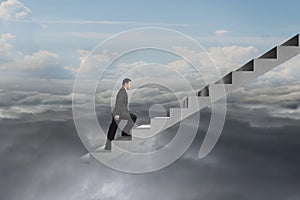 Businessman climbing on concrete stairs with natural cloudy sky