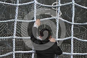 Businessman climbing crisscross rope net on business concept doodles background photo