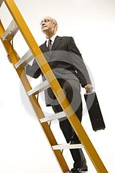 Businessman climbing ladder.