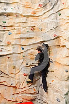 Businessman climbing on man-made cliff