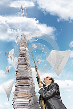 Businessman climbing up the pile of paperwork