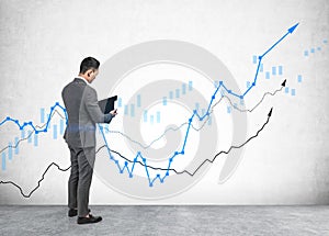 Businessman with clipboard, growing graph