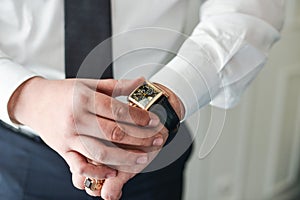 Businessman clock clothes, businessman checking time on his wristwatch.