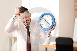 Businessman with clock in office. Time management concept