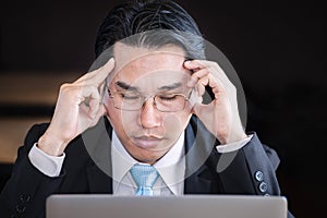 Businessman close his eyes and thinking about business on laptop