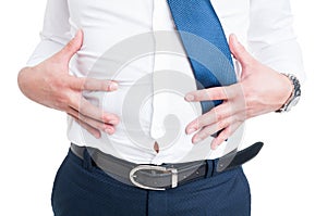 Businessman in closeup holds his stomach because of bloating photo