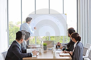 Businessman coaching in team meeting or training, speaker drawing graph on white board business seminar concept