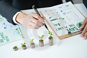 Businessman with coin stack at his office as sustainable money growth. Gyre